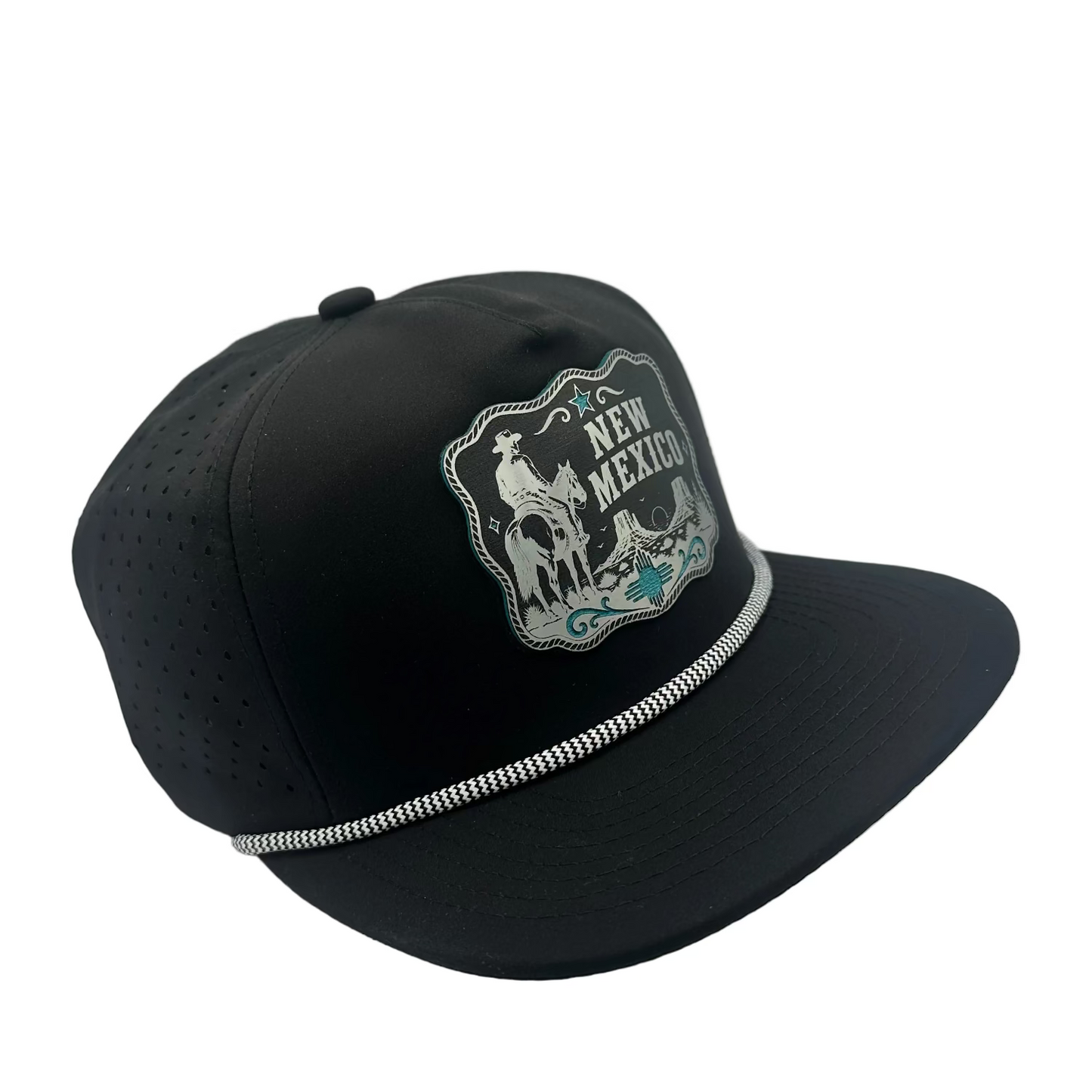 A black baseball cap with a curved brim, featuring a silver and white embroidered 'New Mexico' cowboy patch on the front and a silver decorative trim along the edge of the brim, set against a light gray background.