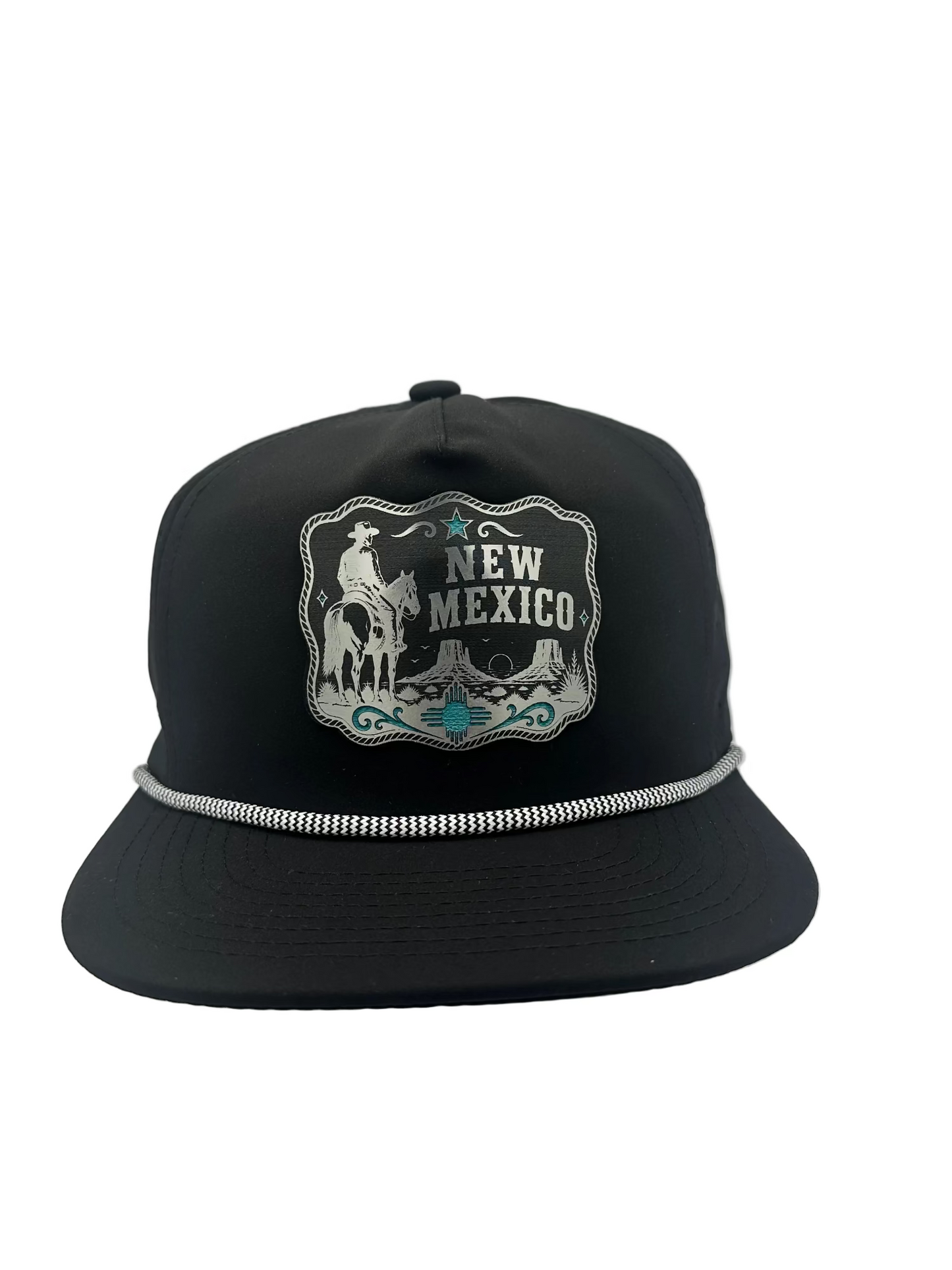 A black flat-brim snapback cap featuring a western-style embroidered patch on the front with a cowboy, horse, and the words 'NEW MEXICO,' plus a silver metallic trim detail across the brim.